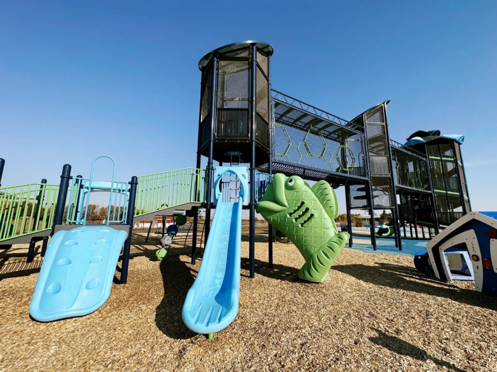 Pogadl Park-6 Close up view of Alpha Climber, Deck to Deck Steps, Chameleon II Slide, Big Kahuna Climber, Tot Builders Playhouse, Hives Skyway, and Hurricane Tower.