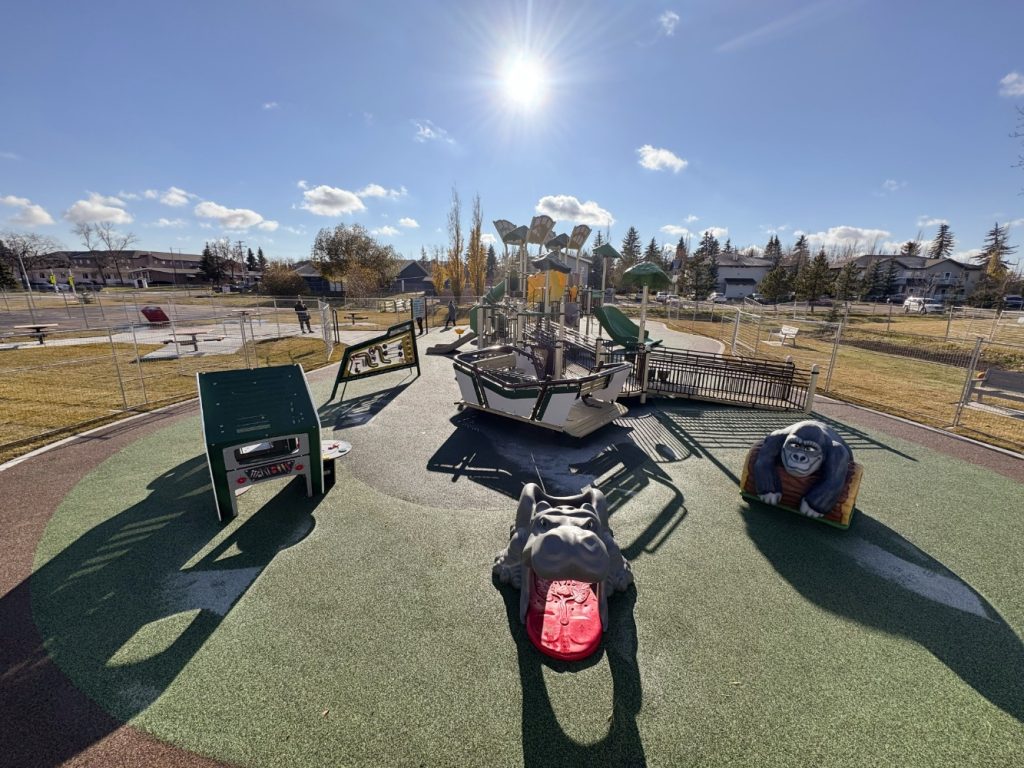 Willow Park School-03 Bright playground at Willow Park School under a sunny sky, featuring a climbing structure, slides, and gorilla and hippo sculptures. The atmosphere is cheerful and inviting.
