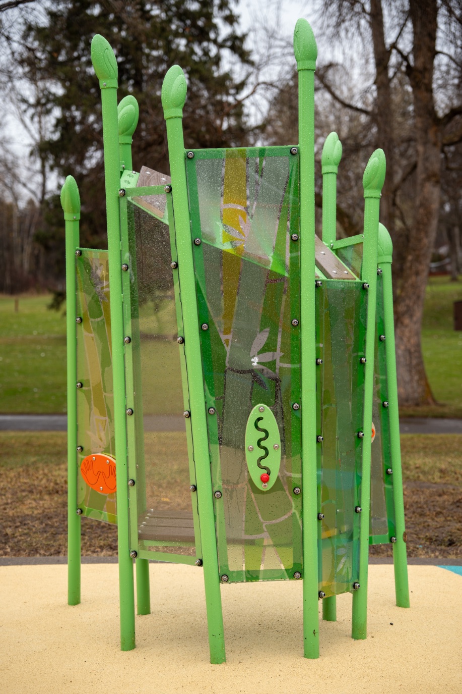 Green sensory play pod with leaf-patterned panels, a tracing maze and hand panel on rubber surfacing.