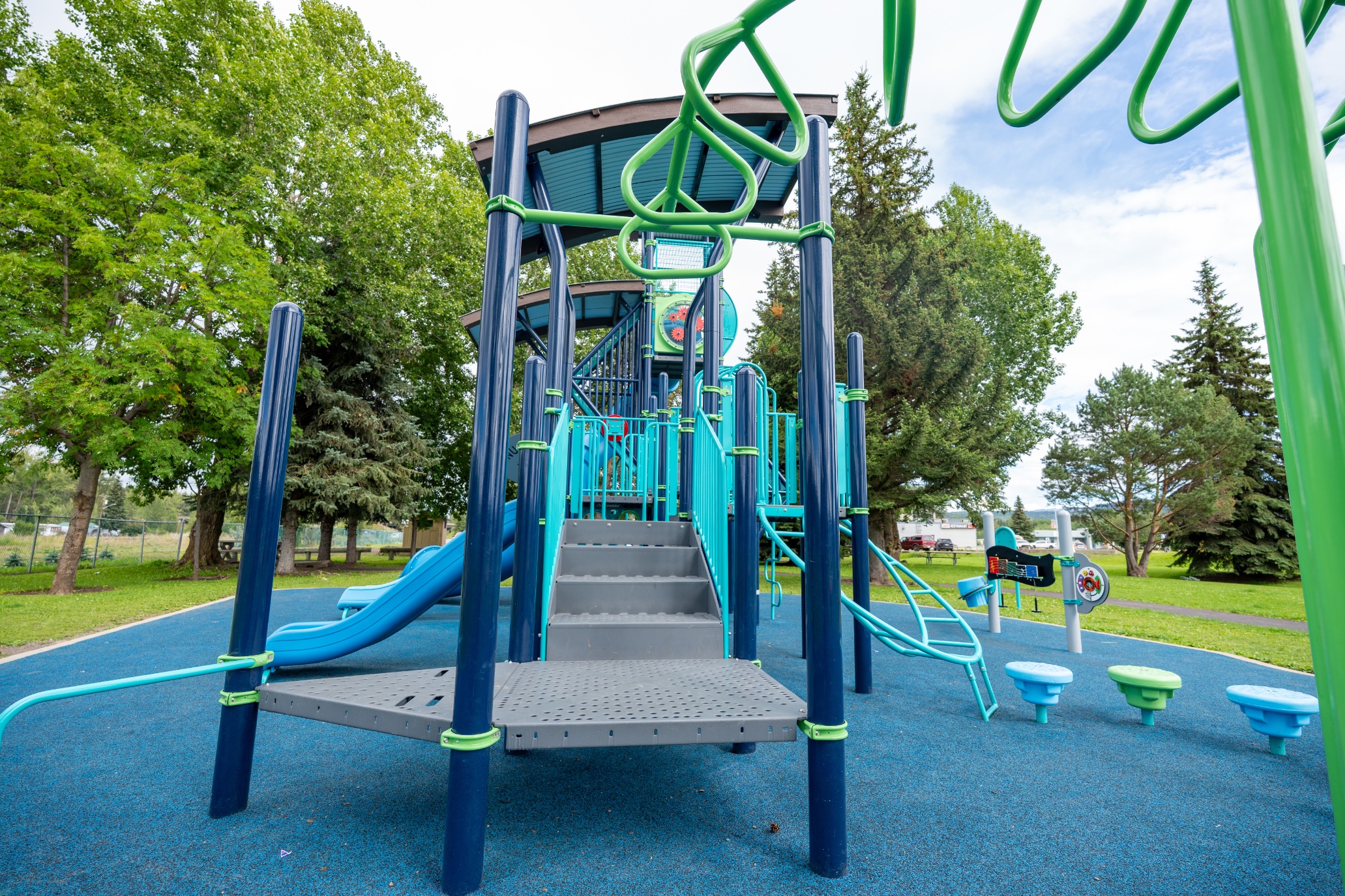 Wide steps and deck entry to the play structure at Steelhead Park in Houston, BC.