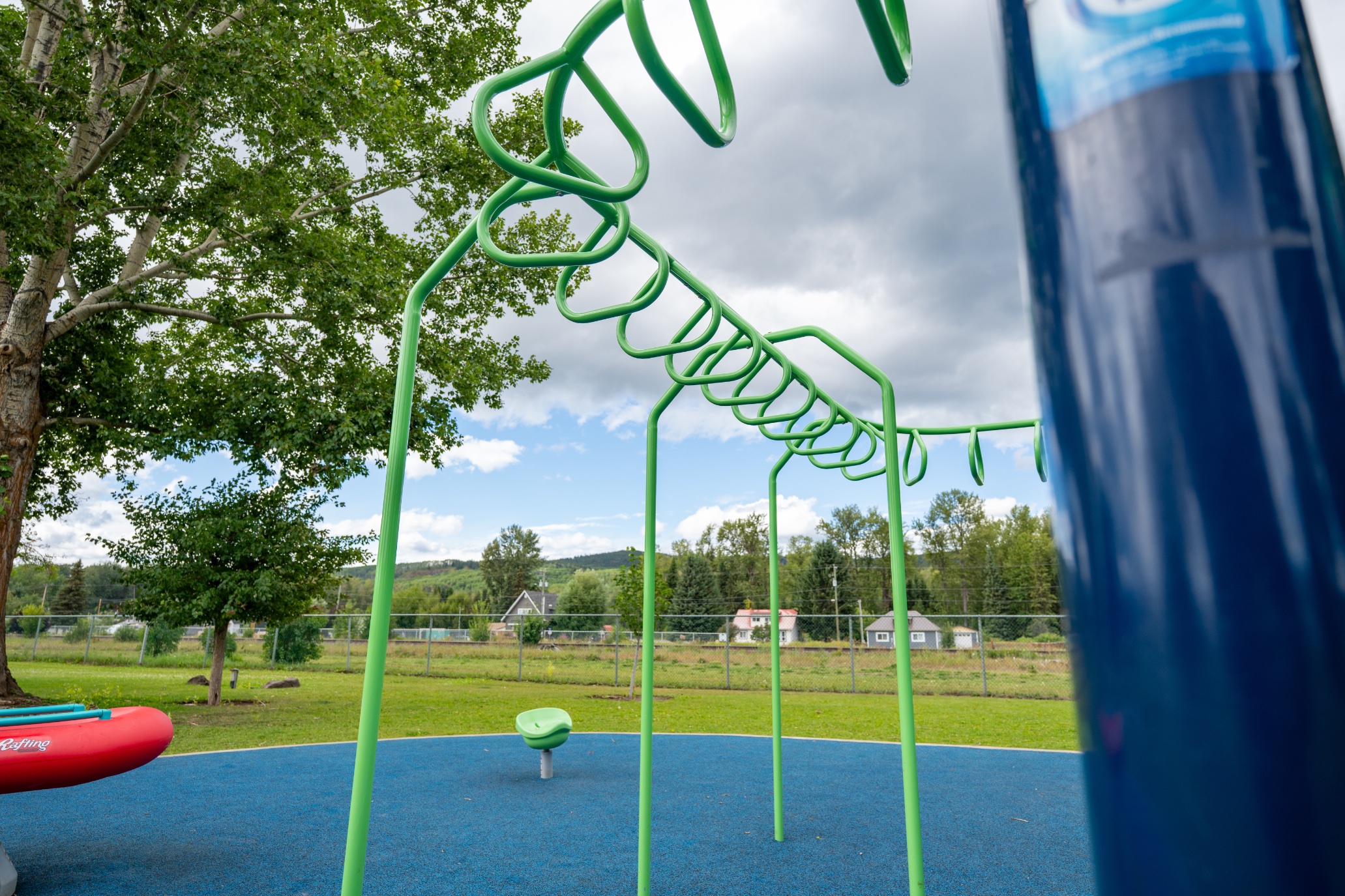 Green overhead monkey bars against the sky at Steelhead Park in Houston, BC