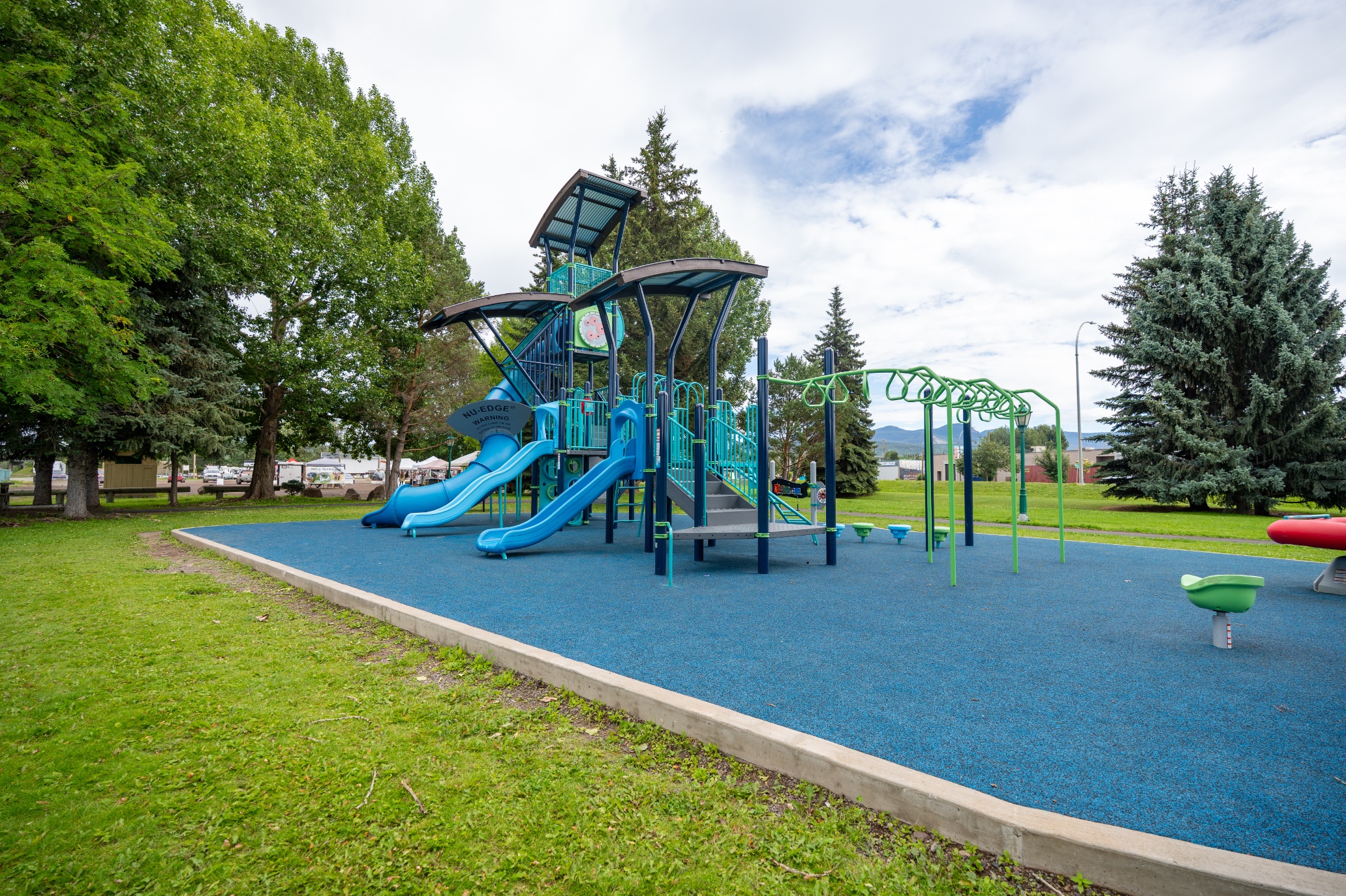 Side view of the Steelhead Park playground in Houston, BC, with slides and green monkey bars.