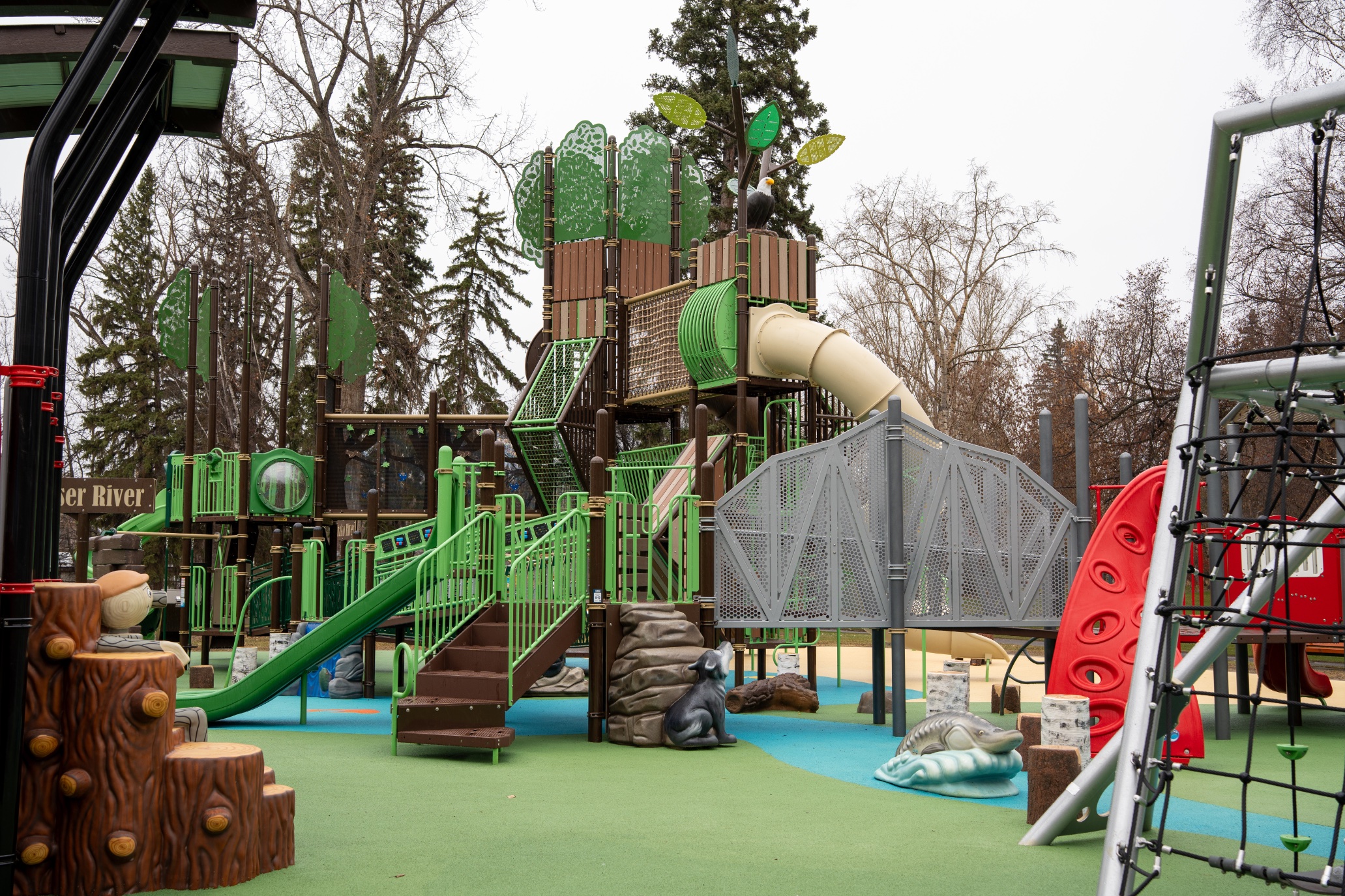 Nature-themed play tower with an eagle, wolf and sturgeon, showing commercial playground design ideas.