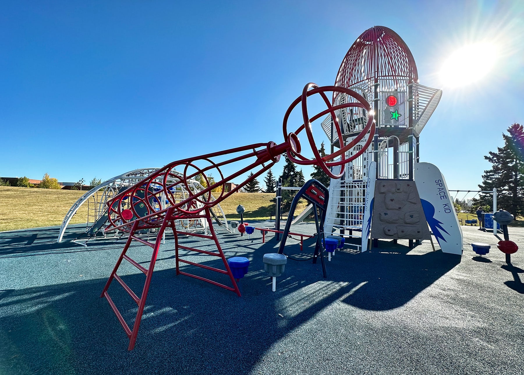Rocket ship play tower and red rocket ship climber, a standout among commercial playground design ideas.