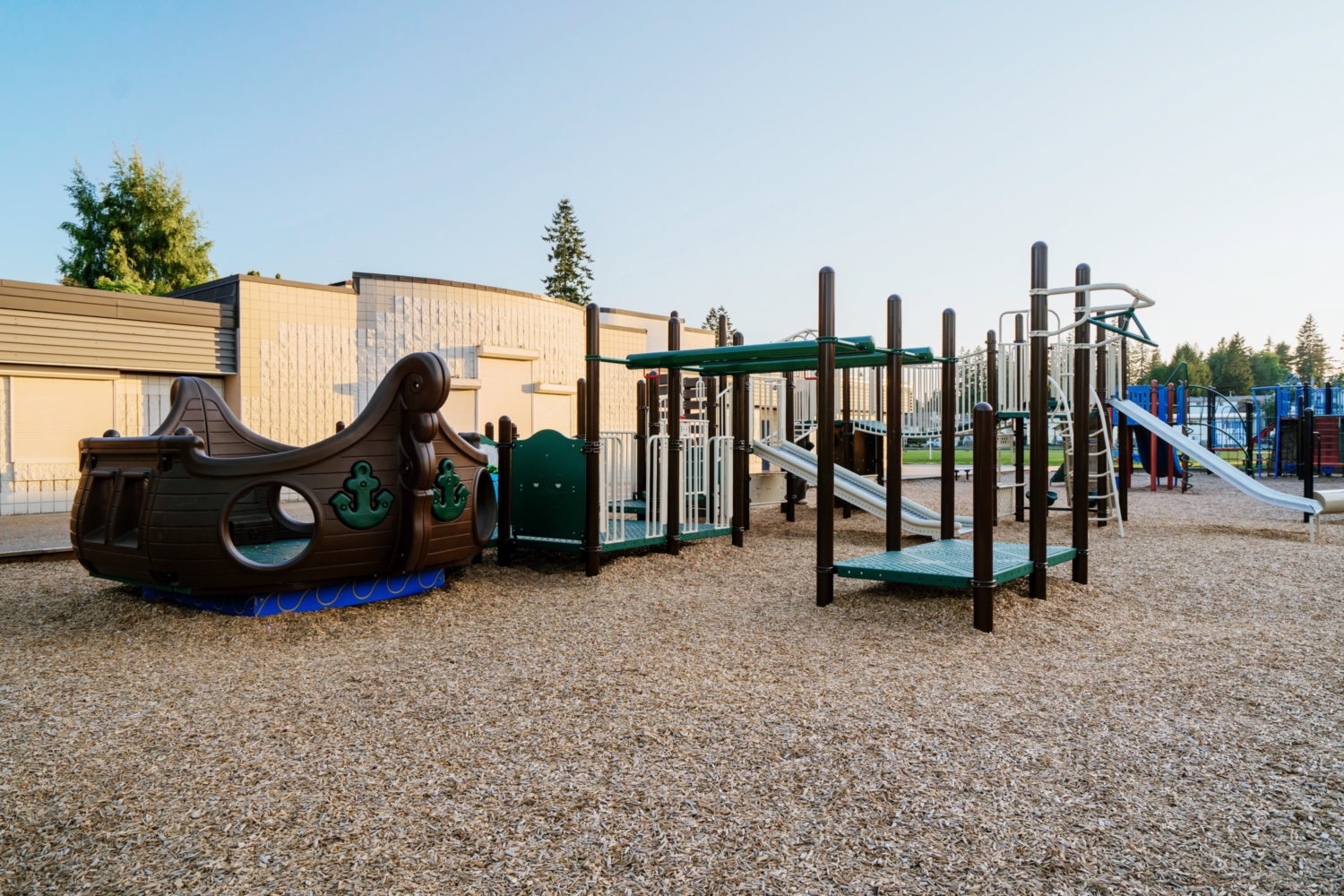 Pirate ship inclusive rocker and metal slides, set beside the building through school playground planning.