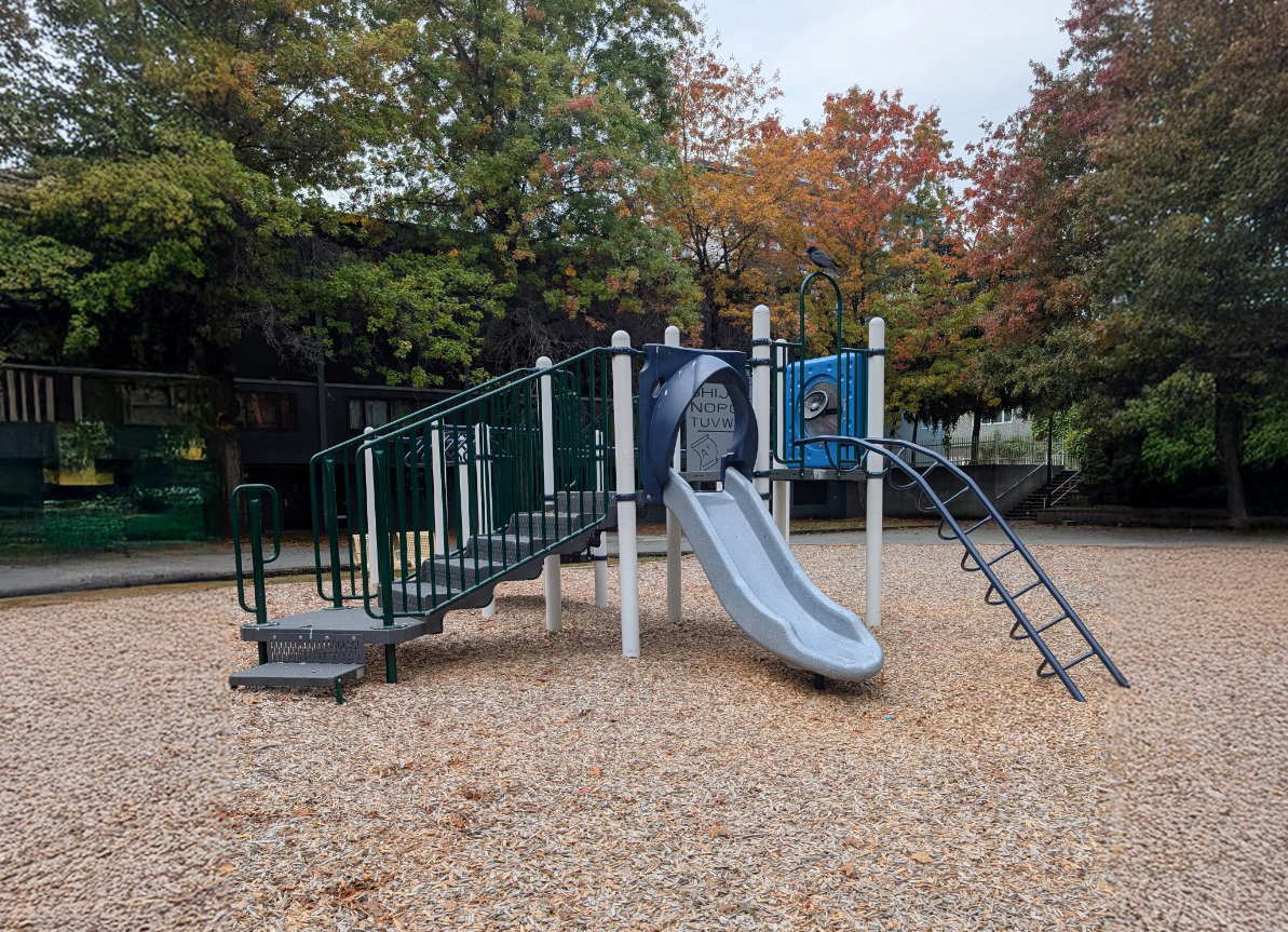 Compact play structure with a grey slide, stairs and ladder, an example of playground equipment for small spaces.